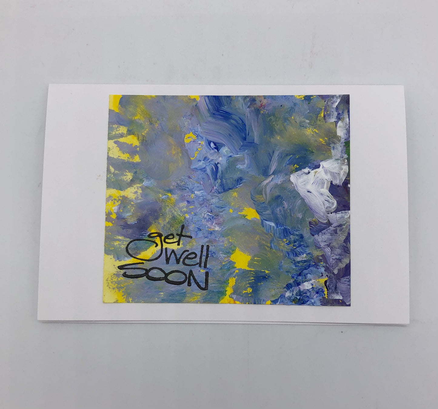 White greeting card with acrylic painting in muted and swirled purple, yellow and white.  On the lower left hand corner Get well soon is stamped in black.