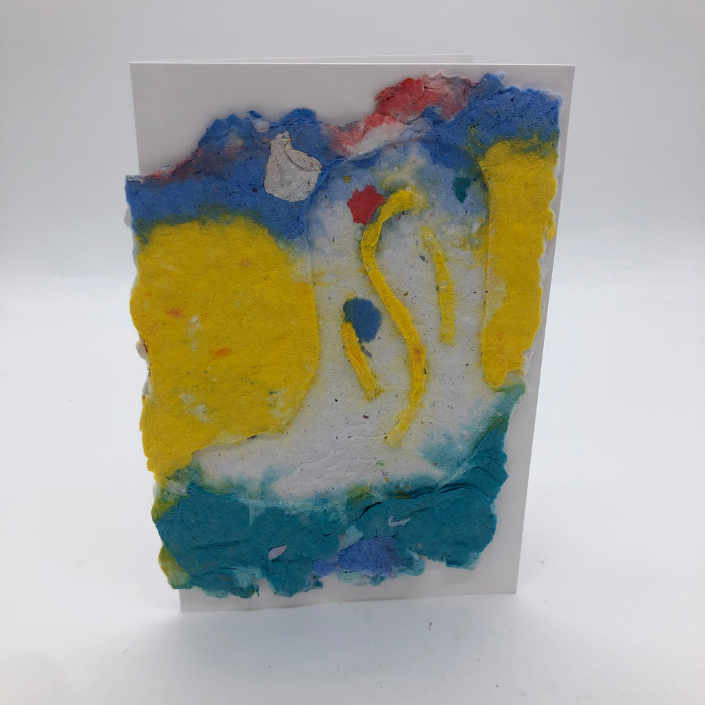 Handmade paper greeting card with background in blue, yellow and teal.  On top is a white cowboy boot with yellow swirl designs.