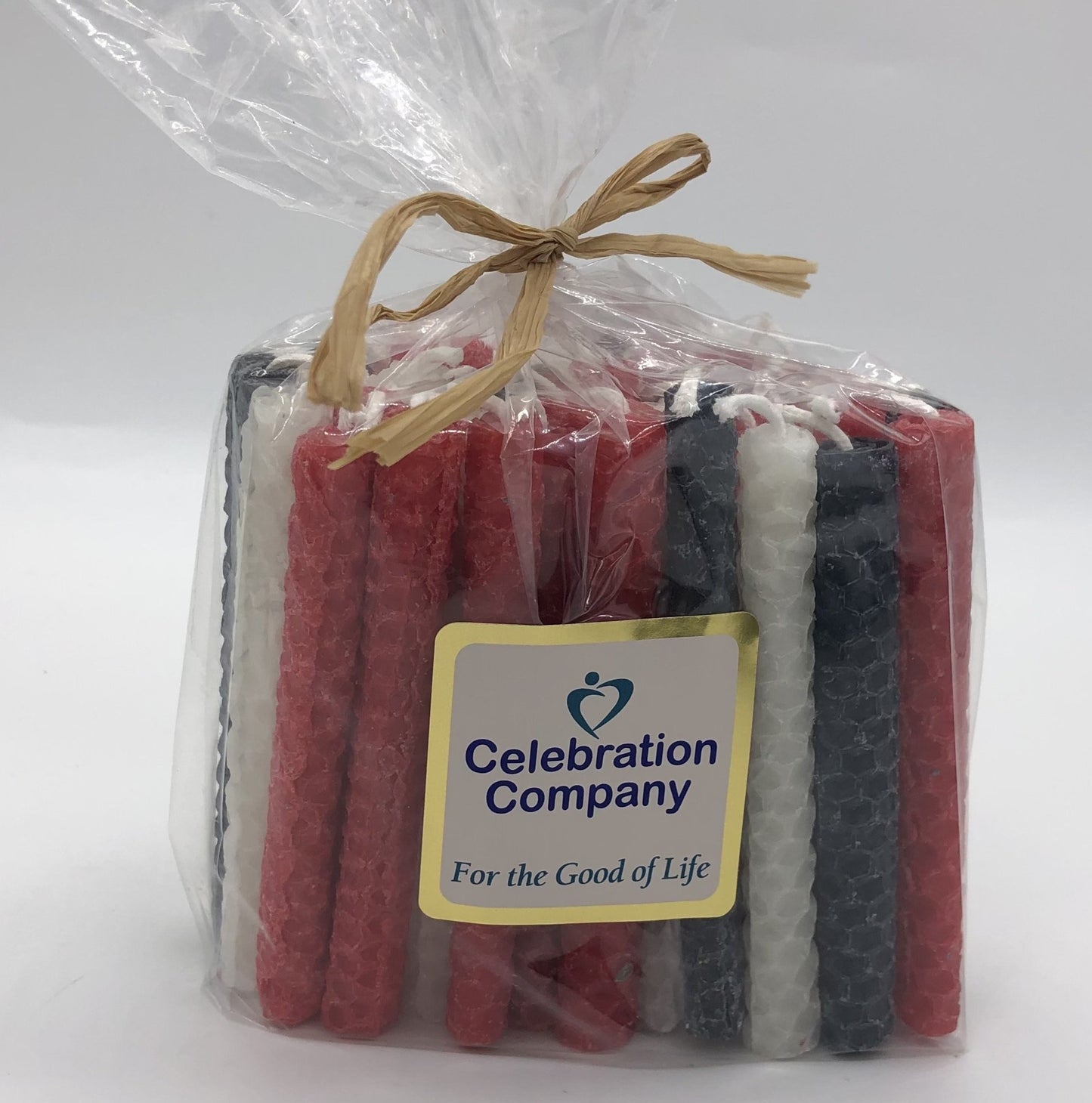 Package of 44 Chanukah candles in navy blue, red and white.  The package is tied with raffia on top and has a white logo sticker on the front.