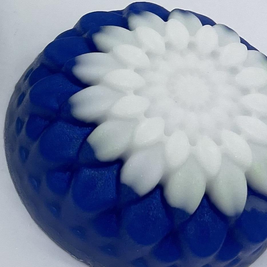 Round floral soap with blue base and white top.