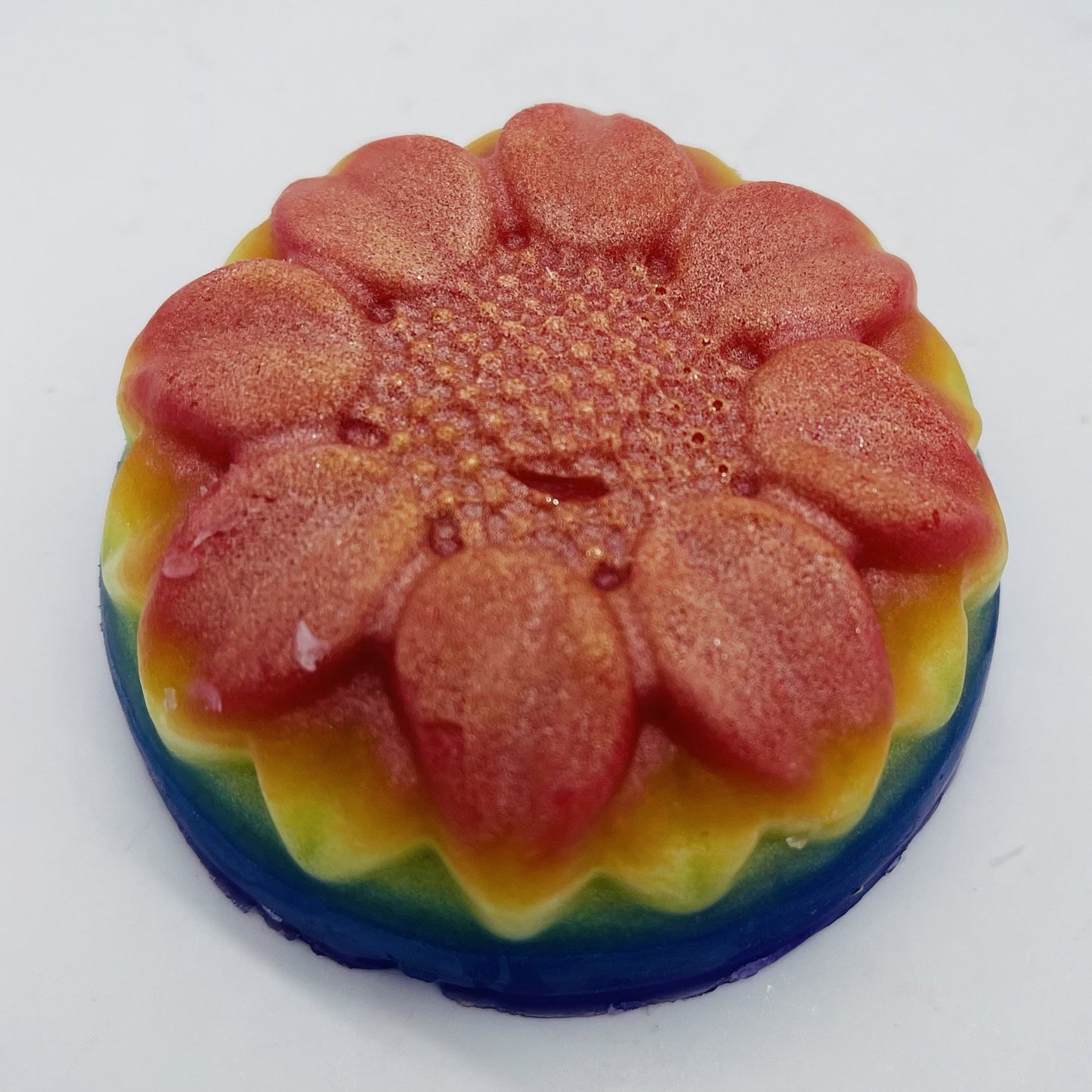 Round floral soap layered in rainbow colors.