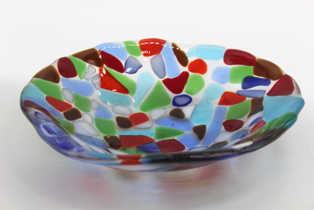 This is a glass bowl with abstract shapes, including colors such as blue, white, brown, red and green.