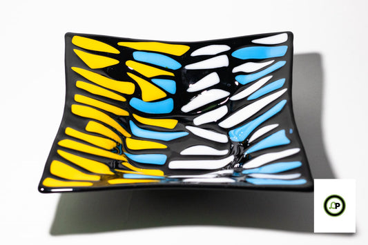black bowl with lines of yellow, white and blue