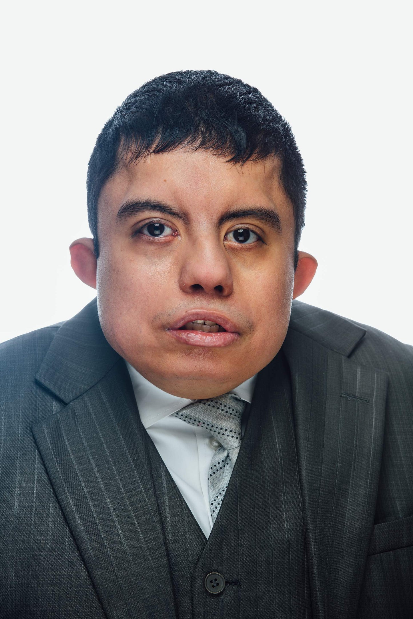 Young Hispanic man wearing a suit and gazing into camera