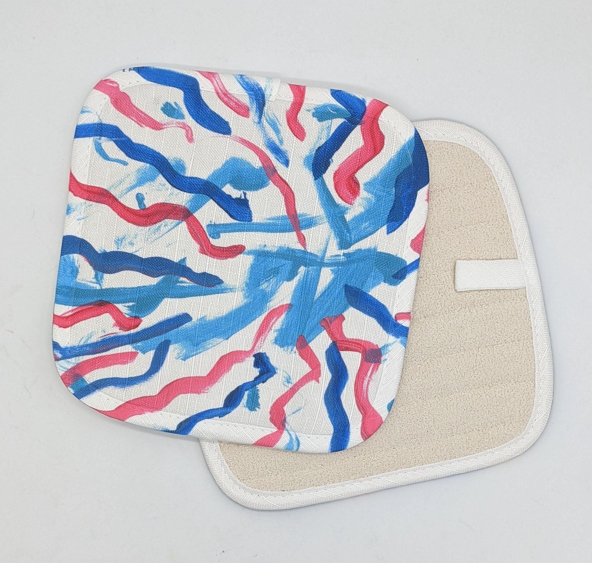 This is a potholder that shows blue streaks of paints with several pink and dark blue squiggles of paint going toward it