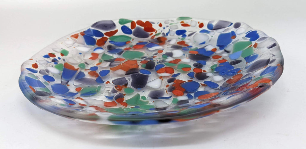Clear glass plate with specks of purple, white, blue, green, orange