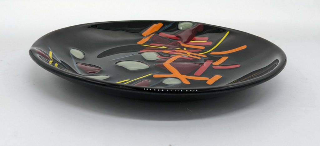 black glass plate with lines of orange, yellow, and red along the center