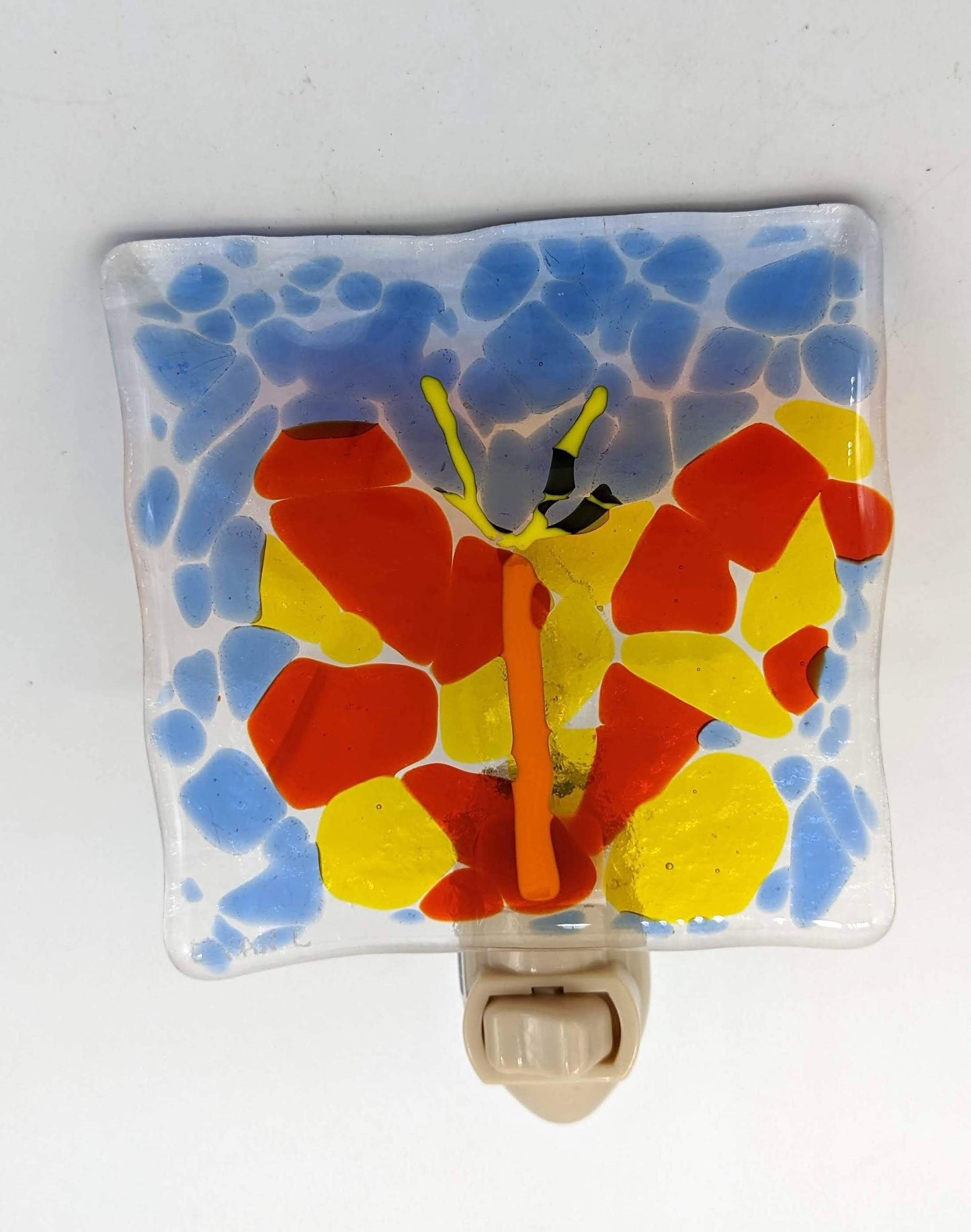 glass nightlight of orange ad yellow butterfly against blue background