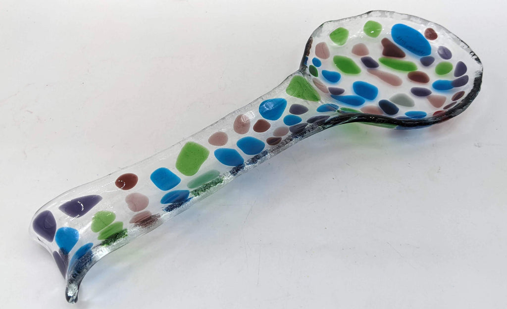 glass spoon rest in the shape of a spoon with blue, green, and purples on top