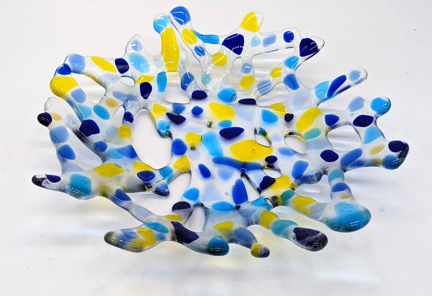 clear glass bowl made of branched glass with spots of yellow and blues