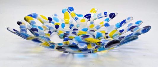 clear glass bowl made of branched glass with spots of yellow and blues