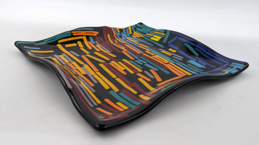 black wavy plate completely covered in colorful lines