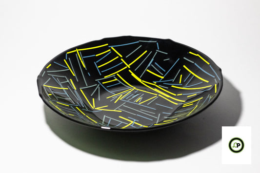 black bowl with lines of yellow and blue