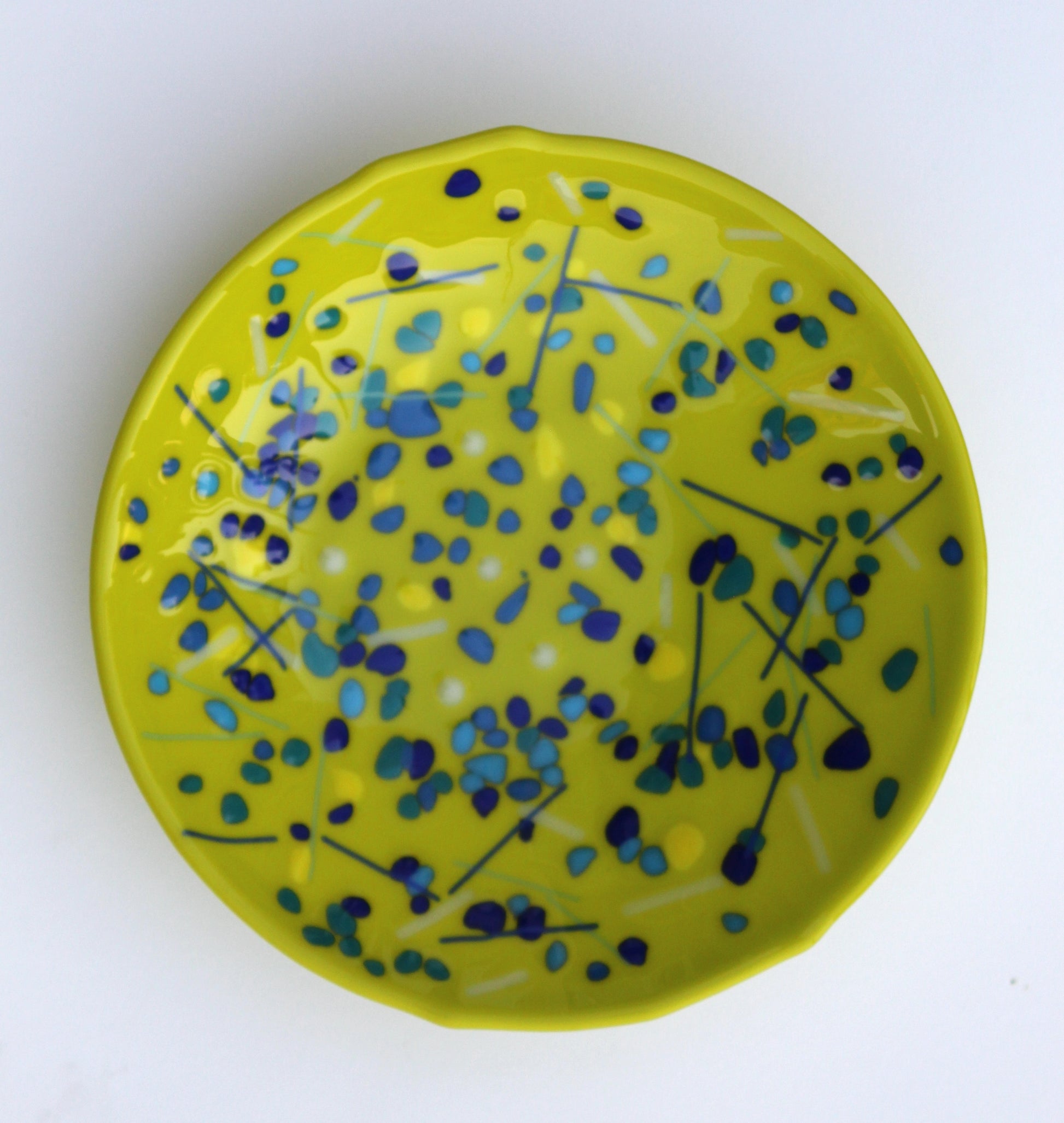 green bowl with blues speckled around with a few lines