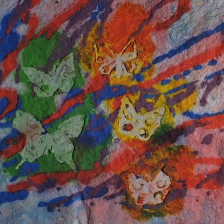 Pigment on recycled paper artwork with five white butterflies against a background of green, orange, light blue, dark blue, and red