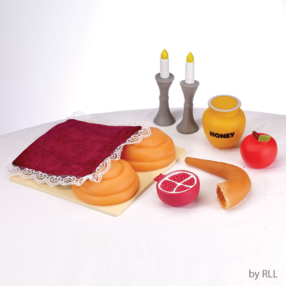 toy challah, Shabbat candles, honey jar, apple, shofar and pomegranate 