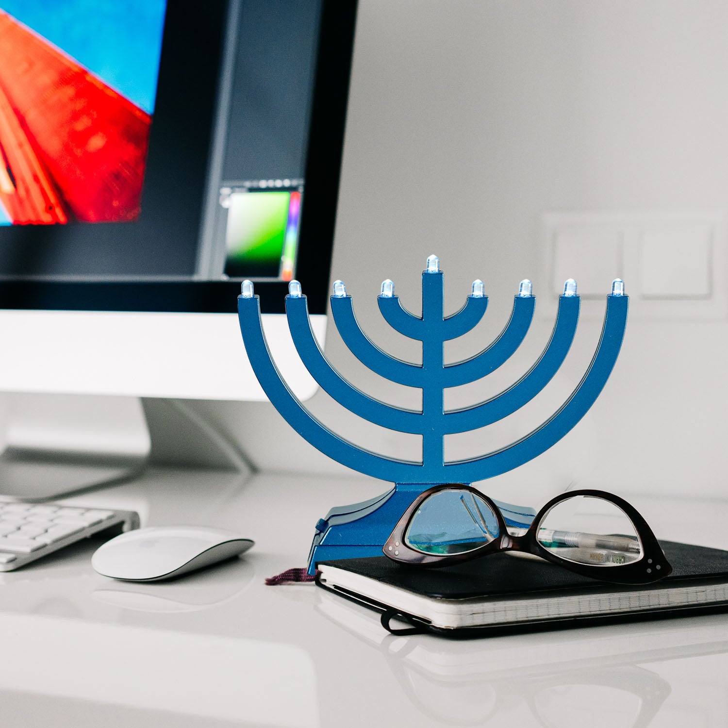 blue menorah sitting in front of computer monitor 