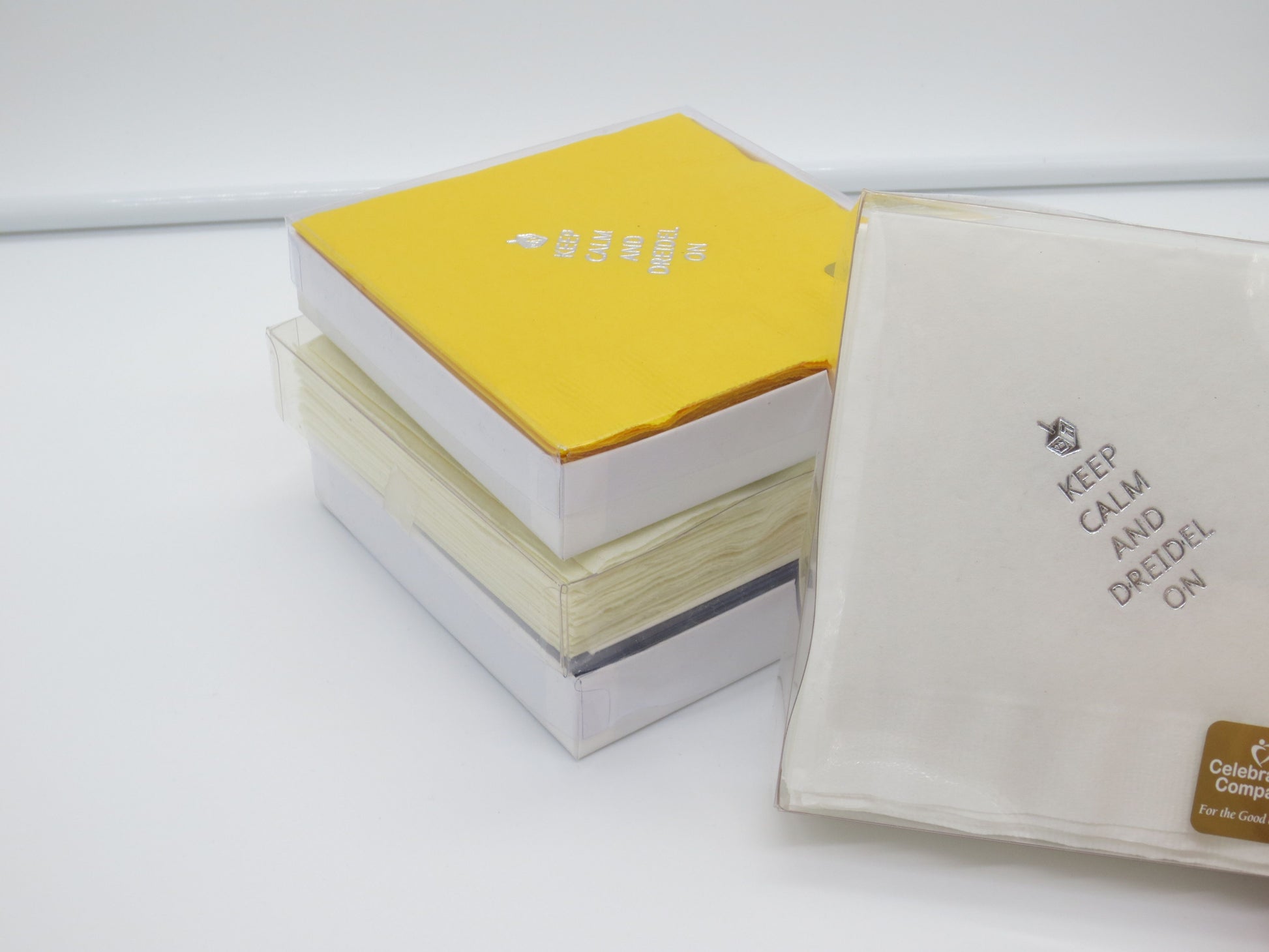 Packaged white and yellow cocktail napkins with silver dreidel and Keep Calm and Dreidel On slogan