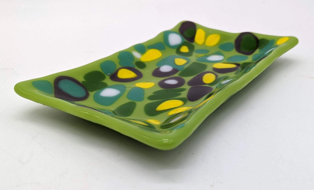 green glass soap dish with spots of green, yellow, and white