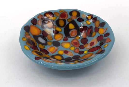 blue trinket bowl with spots of reds and yellows on top