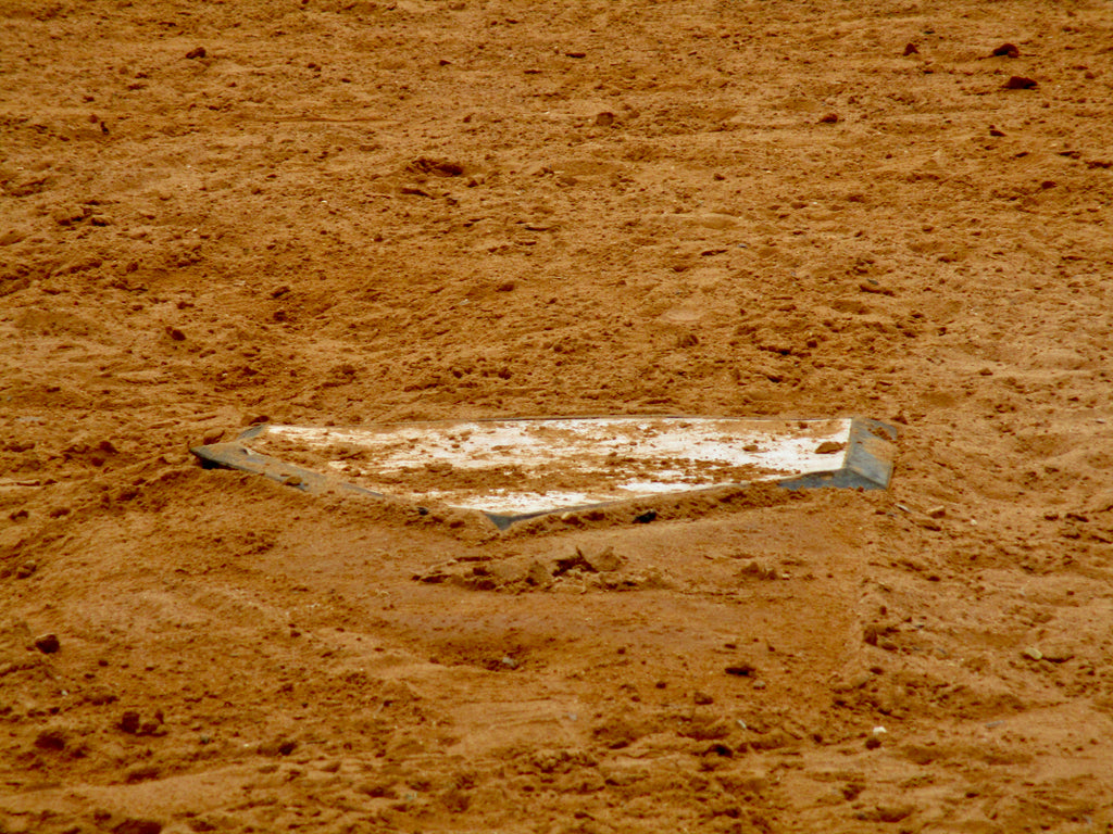 This is a photograph of a baseball base in the dirt.