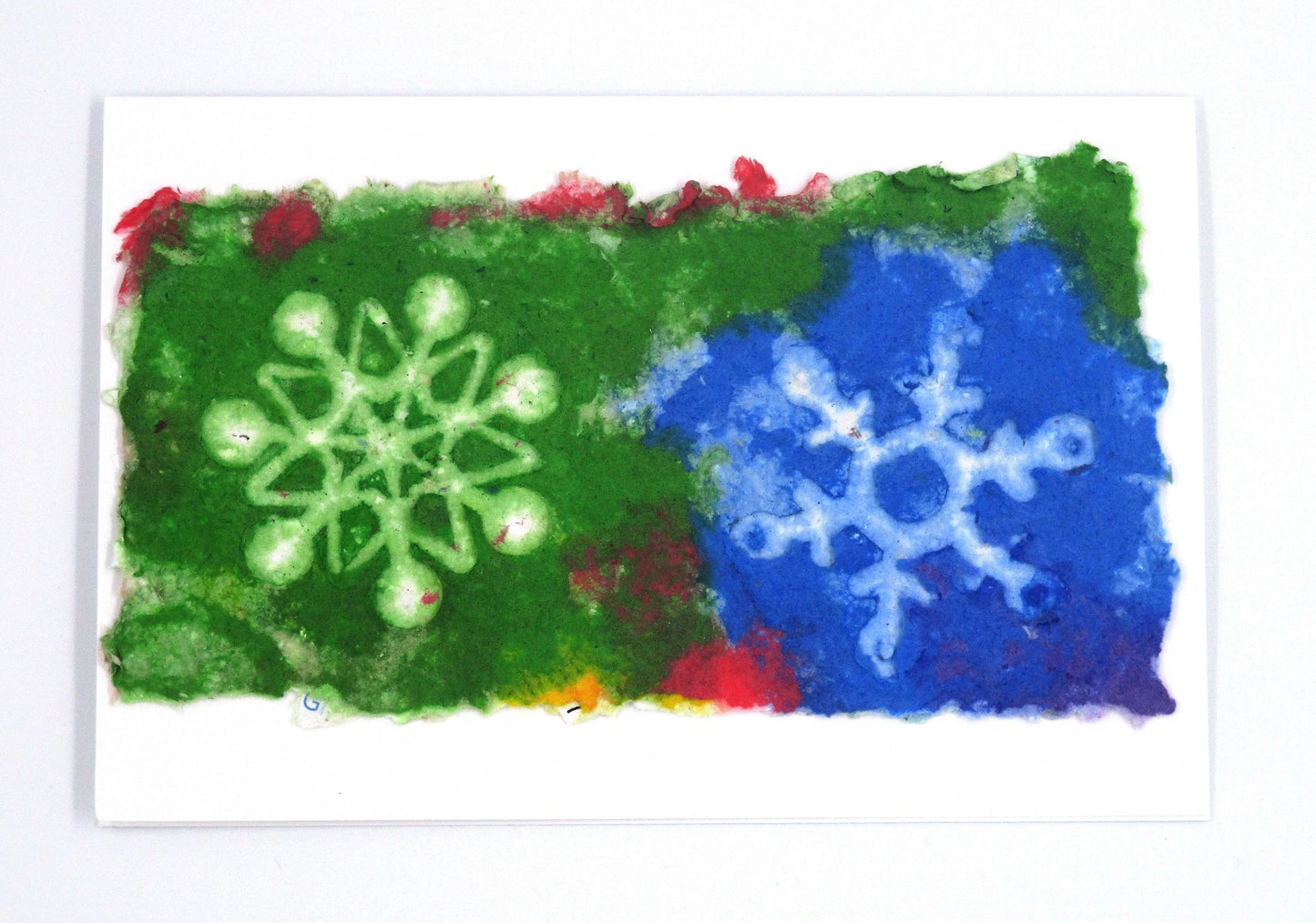 Handmade paper greeting card with green and blue background with two white snowflakes