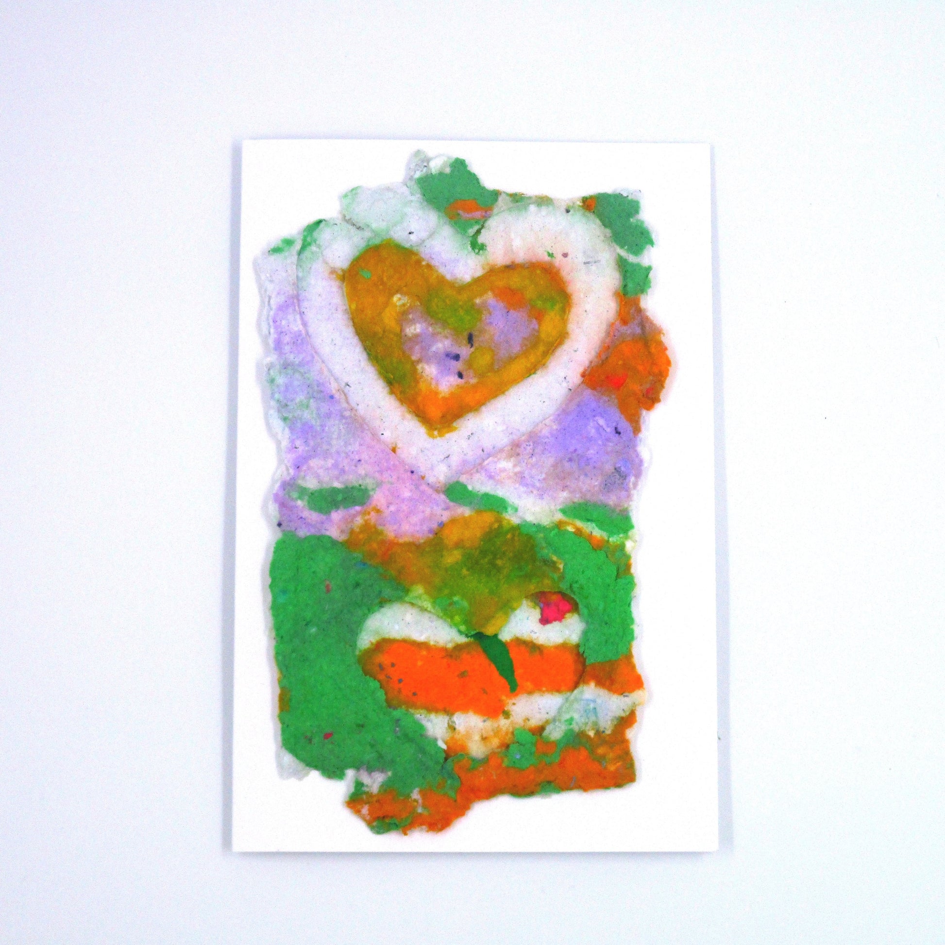 Handmade paper  greeting card with purple, orange and green colors and a white and yellow heart