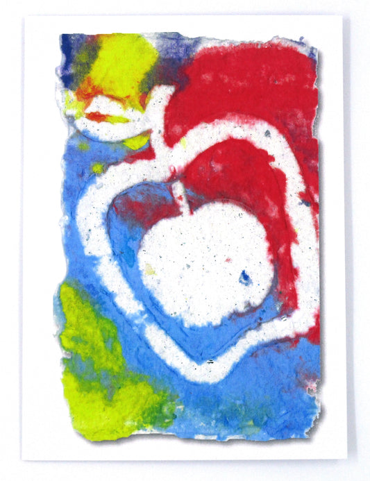 Graphic greeting card with red, yellow and blue background with white stamped apple over top