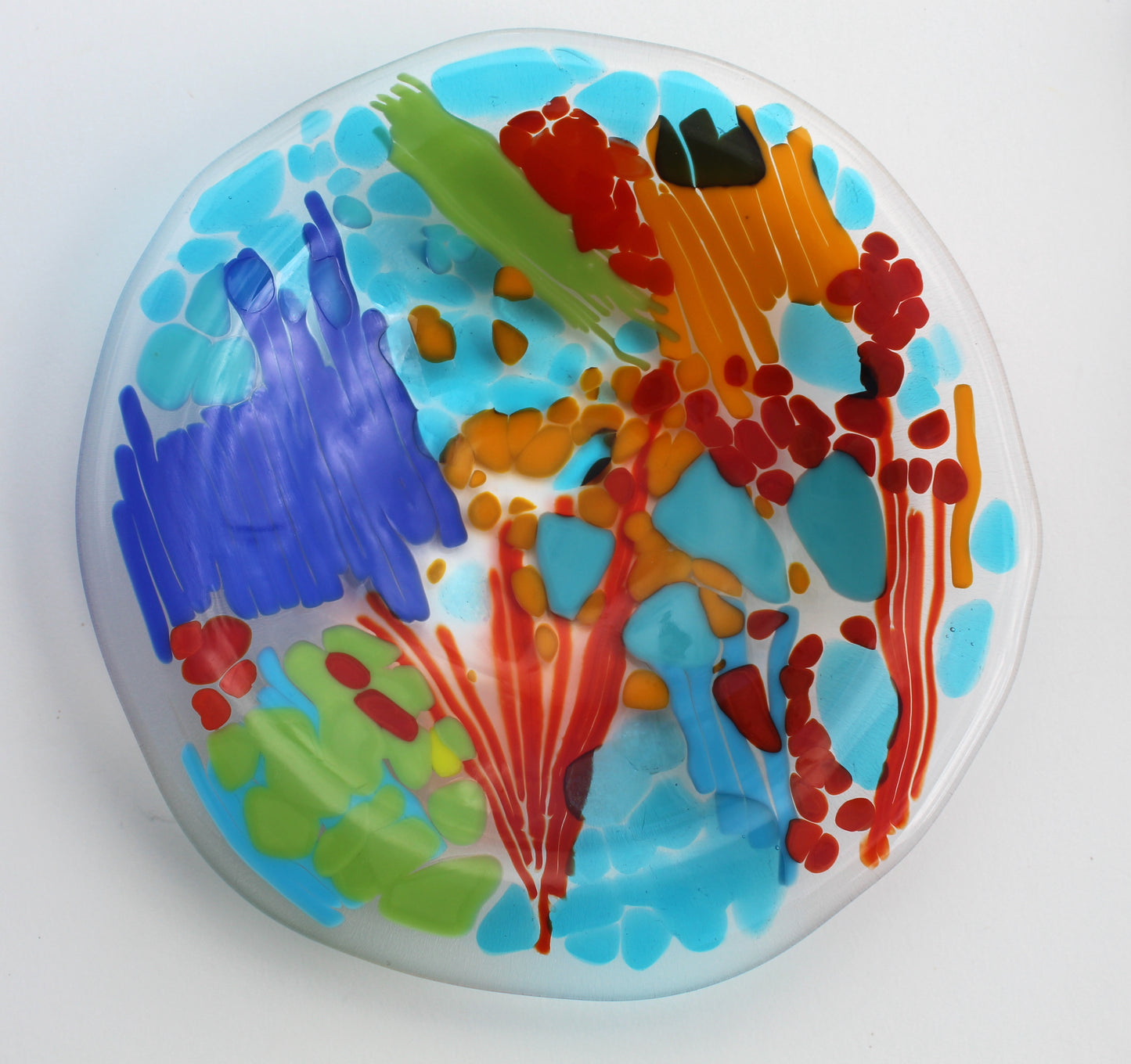 Glass bowl with sections of mostly blues with spaces of orange, red, and green