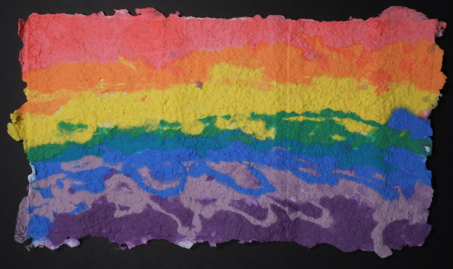 Highly textured handmade paper with horizontal lines of color (starting at the top) red, orange, yellow, green, blue, light purple, and dark purple.