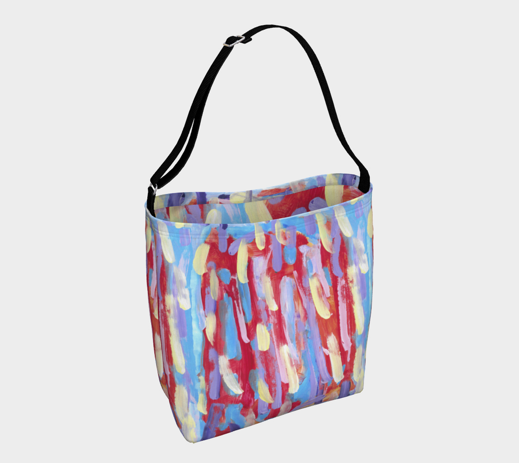 Back side of Crossbody Bag, with black strap, against an orangish-red blackground are pale streaks of pink, yellow, lavender, and sky blue. 