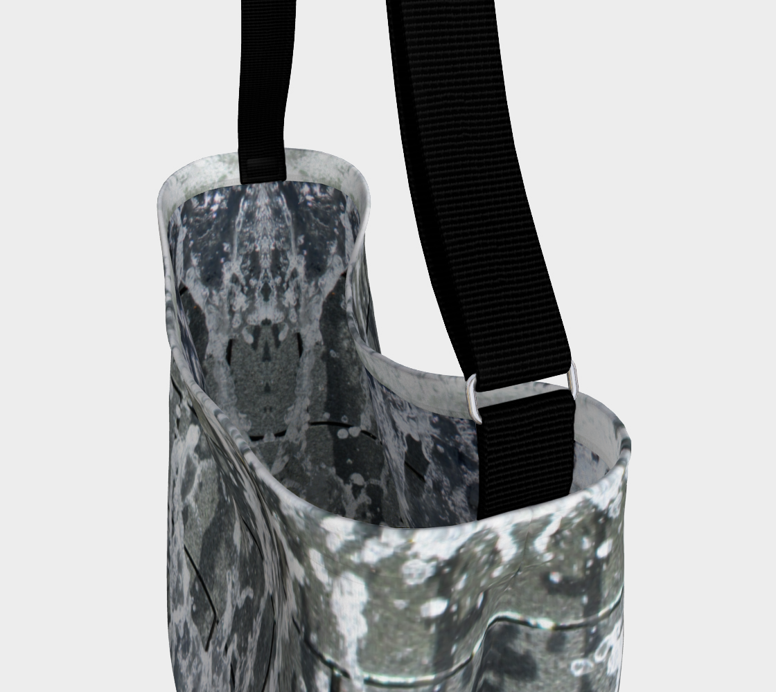 Close up view of black strap and inside of tote with gray, white and black design depicting running water