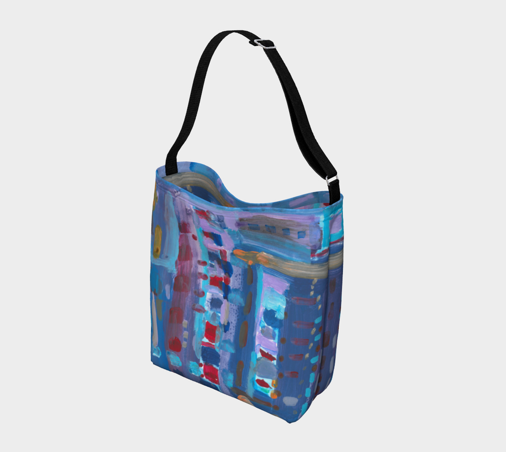This is an additional angle of a crossbody bag with the following painting: This is a painting comprised of several different shades of blue lines in different directions. There are orange, red, and purple shades as well.