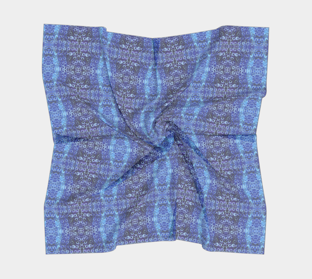 a square scarf of shades of blue and purple with light blue rings printed all over