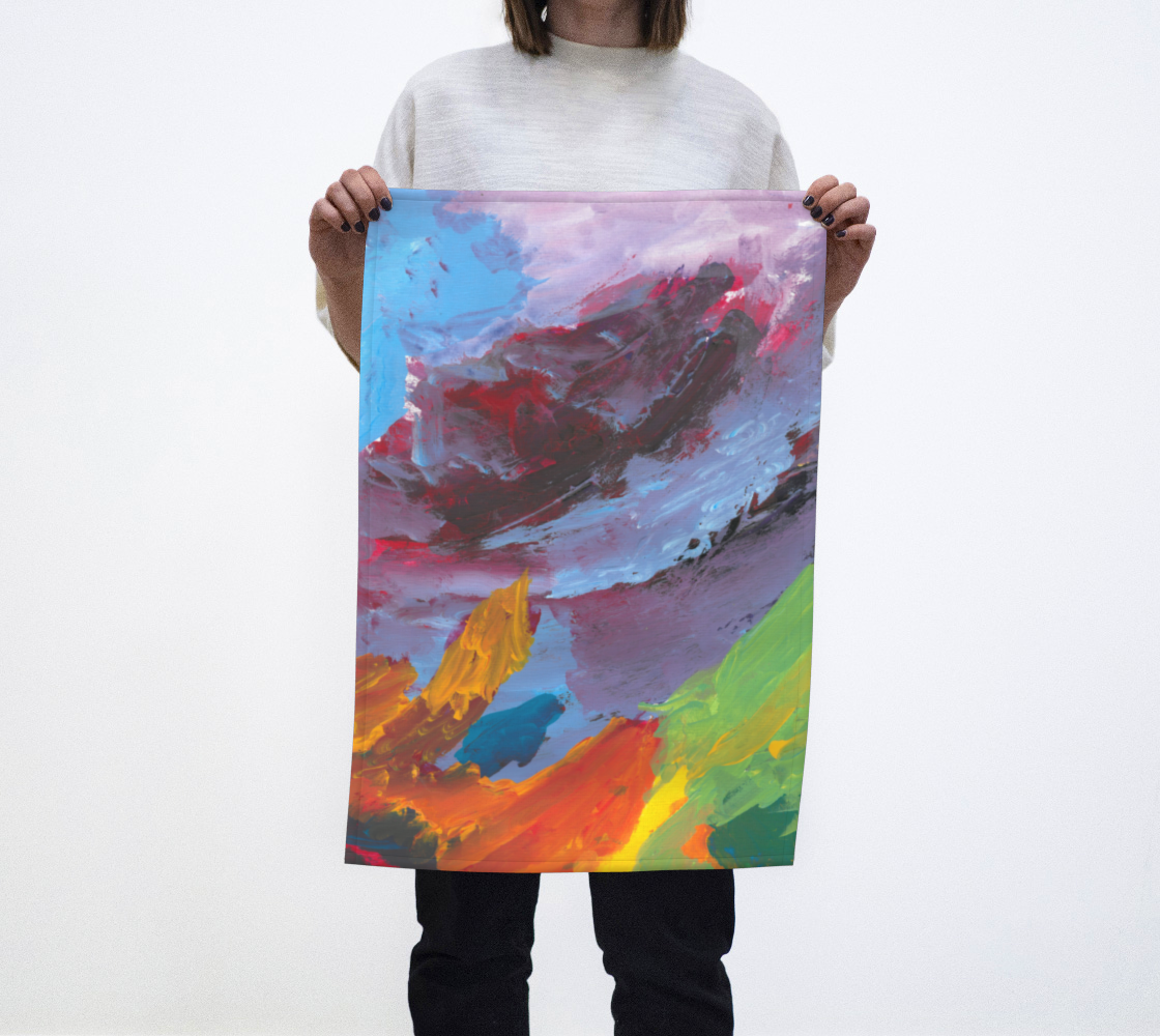 Woman holding tea towel with lavender, light blue, green, yellow, orange and red paint streaks