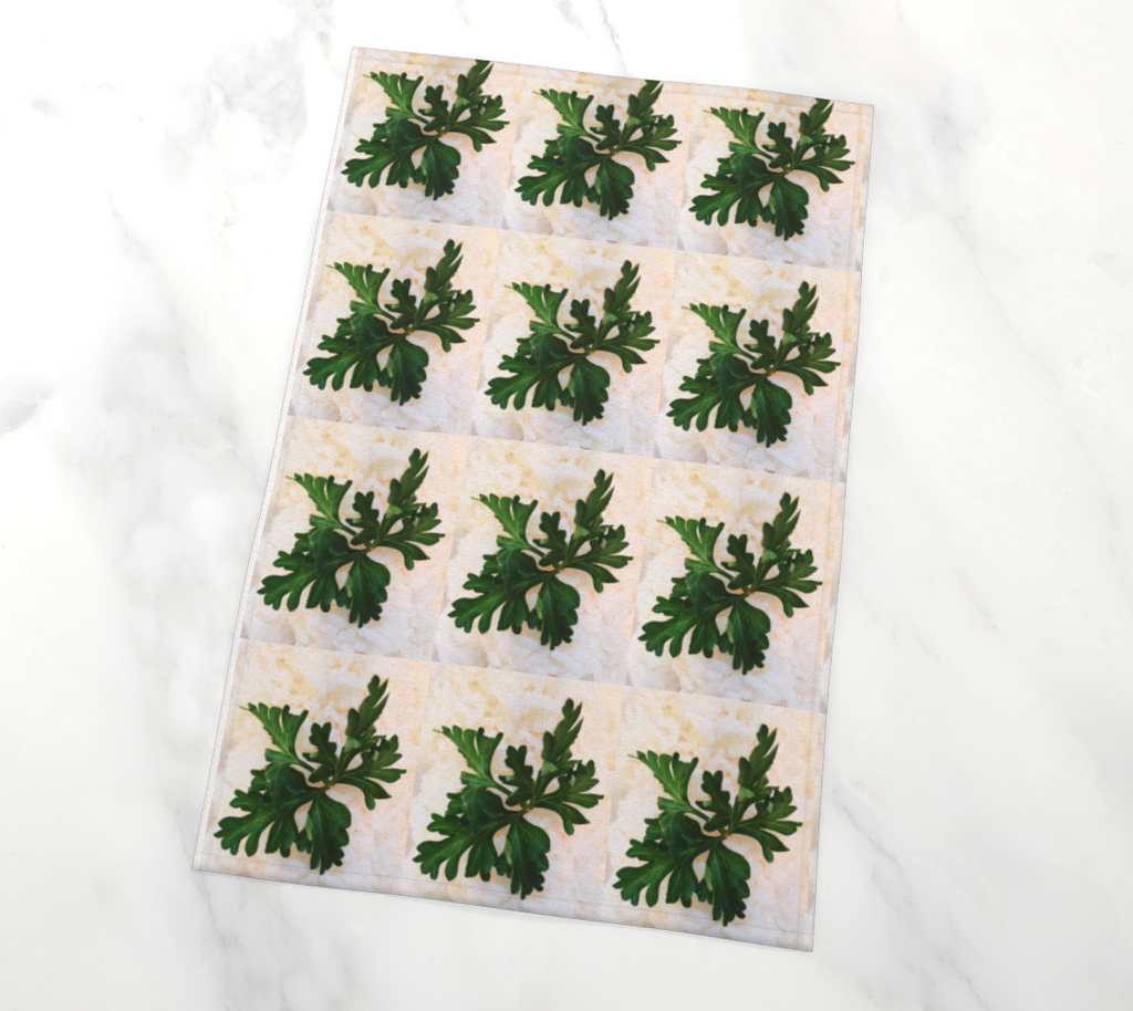 Tea towel of duplicate images of a green herb against white rice.