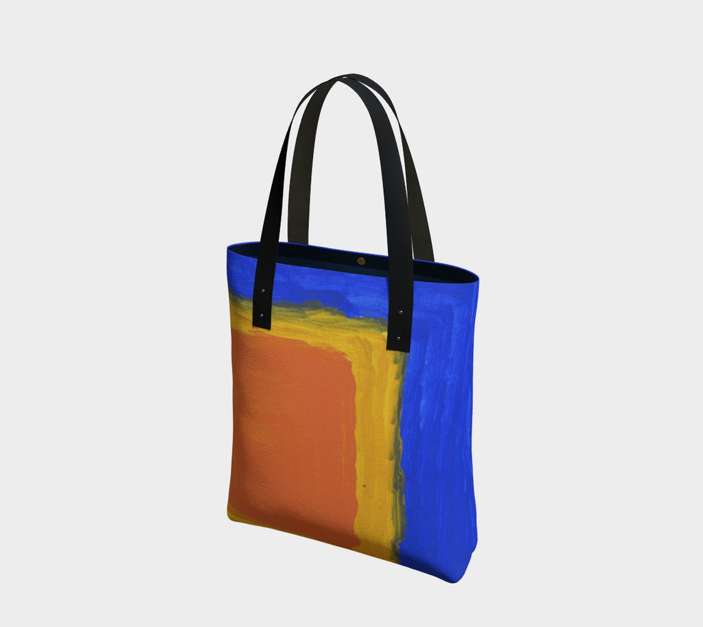 Lined tote bag with magnet clasp and vegan leather black straps. The pattern is a blue background and large yellow and orange square in lower right hand corner