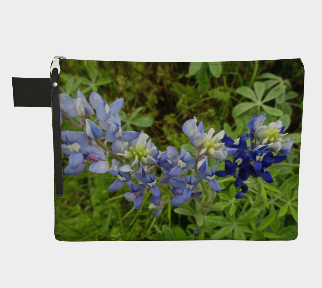 Front view of CarryAll Bag with light blue and deep blue flowers with greenery photograph design. Black wrist strap and zipper closure.