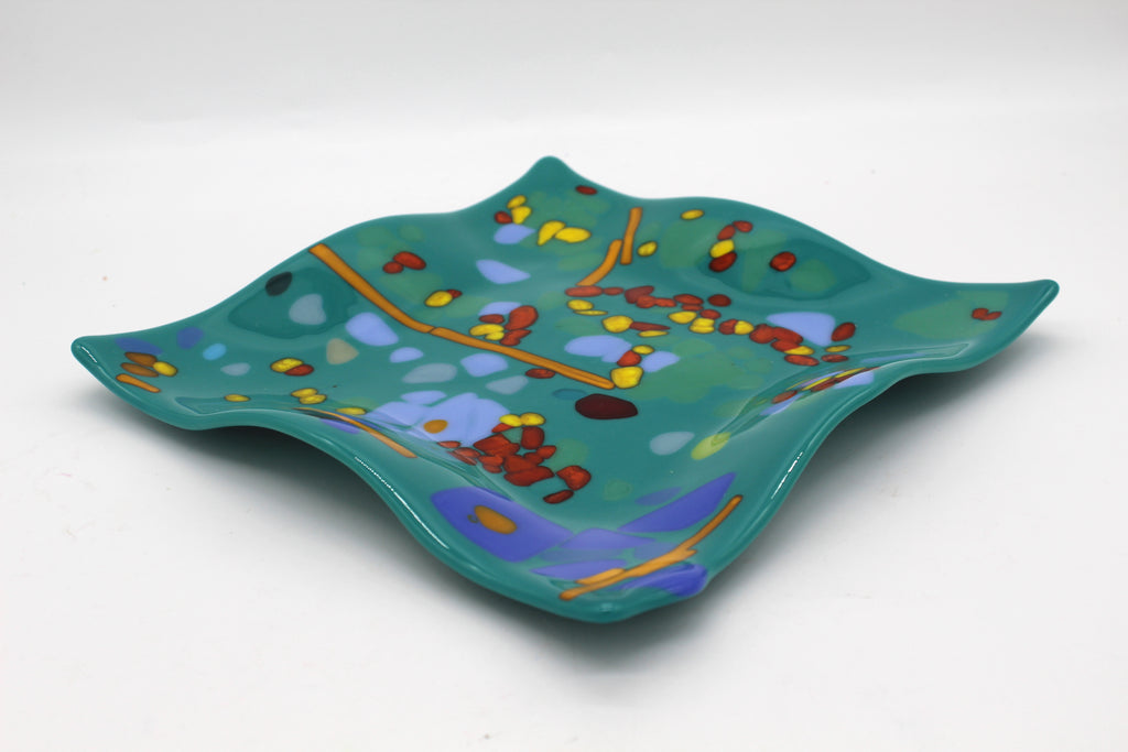 Teal glass wavy plate with accents of orange, yellow, red, and blue
