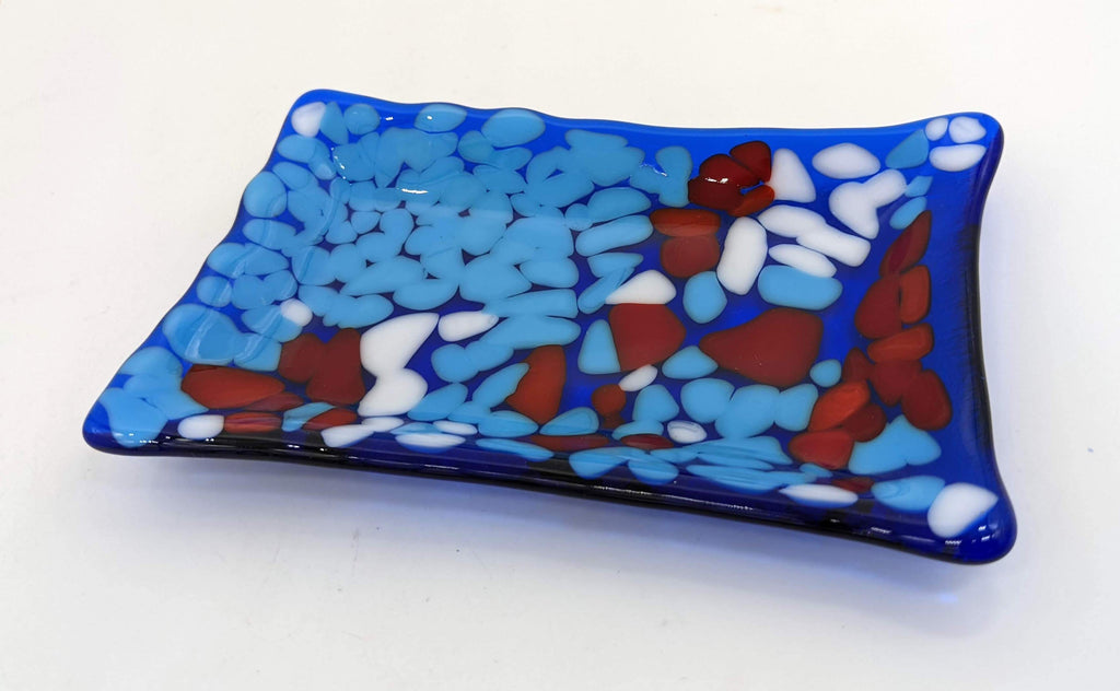 transparent blue soap dish with blue, red, and white on top