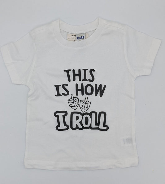 White toddler t-shirt that reads "This is how I roll" with 2 dreidels.