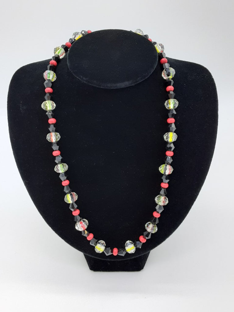 Necklace with pattern of beads alternating: clear glass, black, red, black, and clear glass