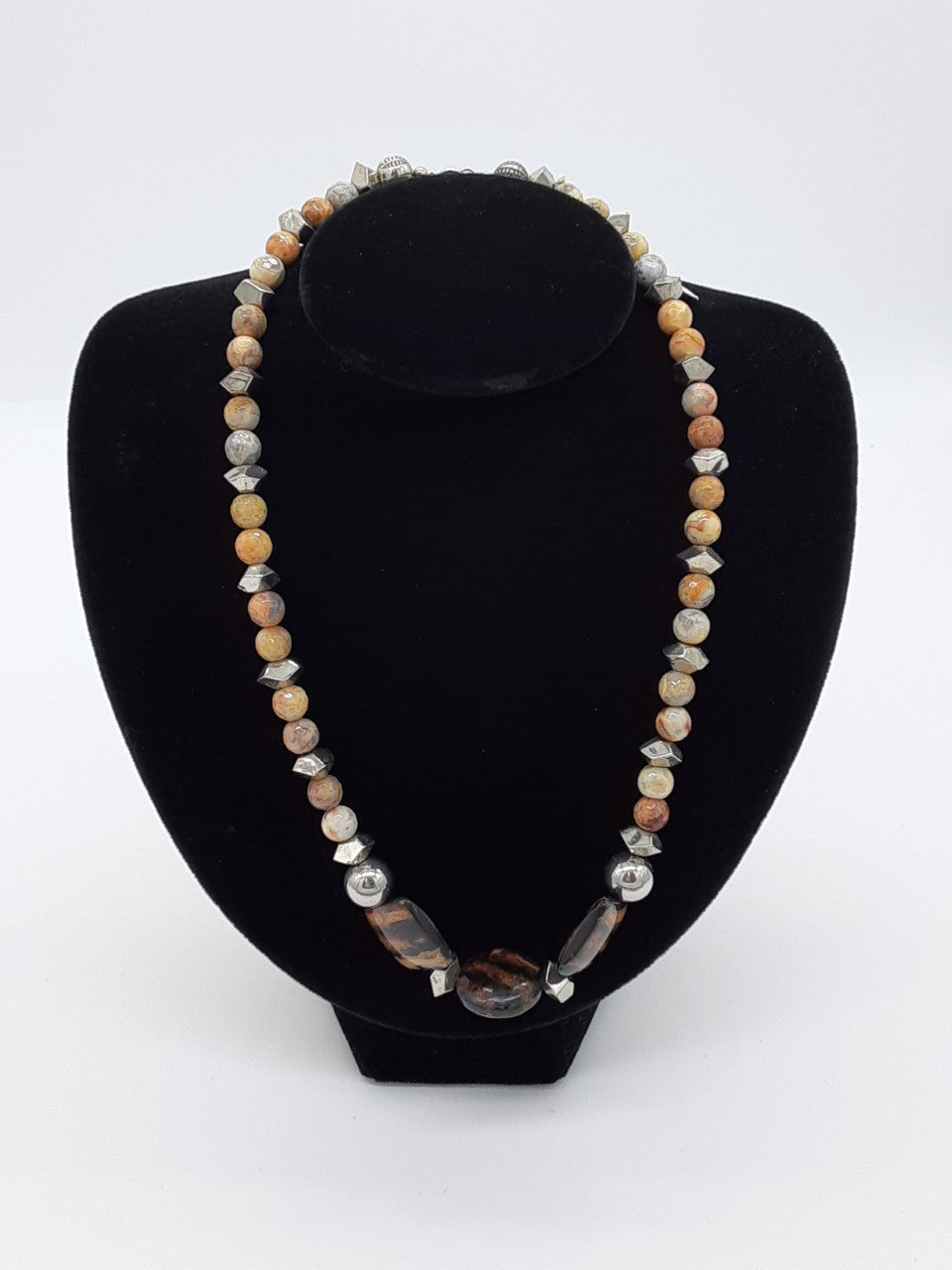 Necklace of beiges , with three tiger striped beads in the center- alternating silver
