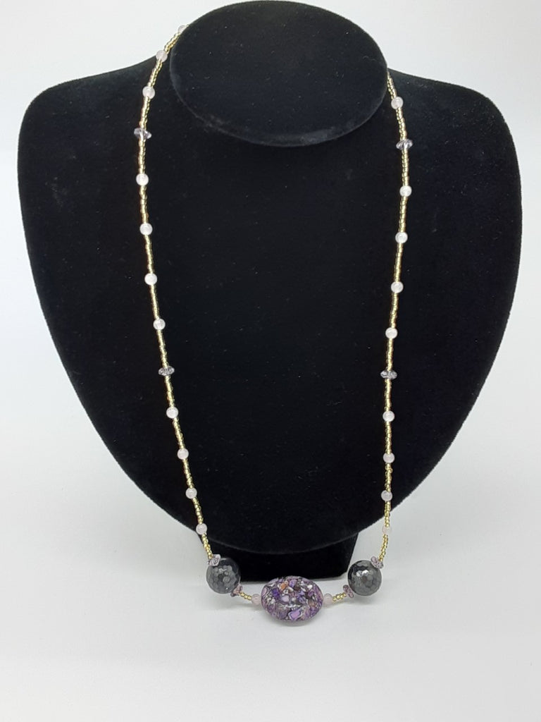 skinny necklace with the center piece being a purple and white marbled stone with two silver faceted beads on either side