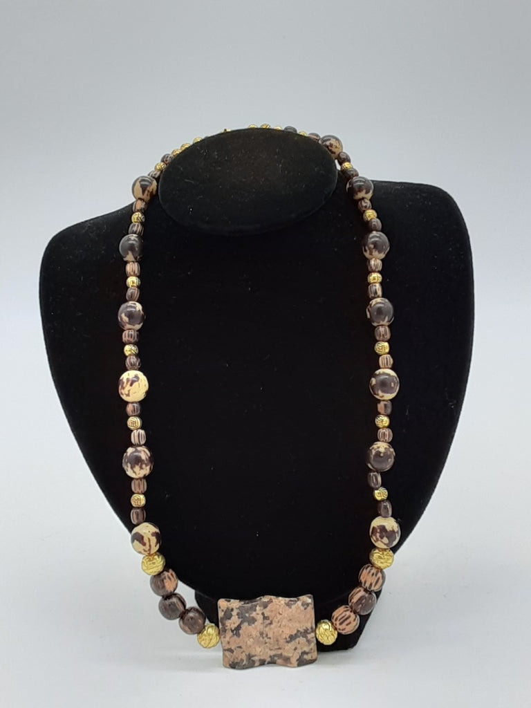 necklace with shades of brown round beads with small gold beads in between.  The center piece is a large rectangle piece of agate