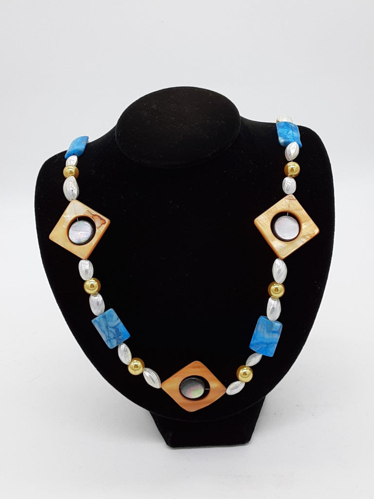 blue, white, and gold colored necklace. with three diamond shaped beads