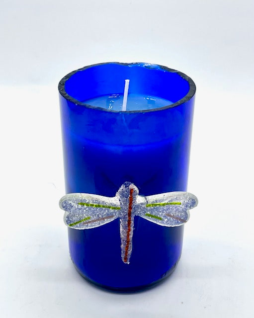 blue glass with glass dragonfly attached to outside