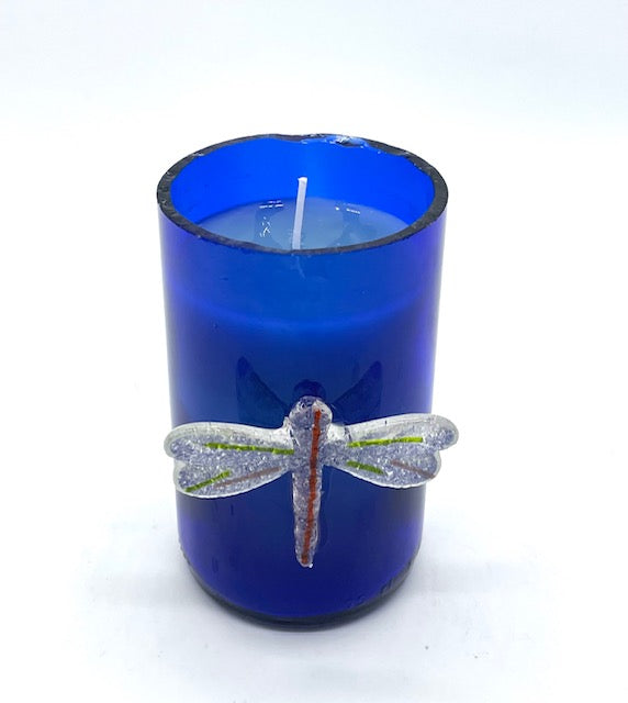 blue glass with glass dragonfly attached to outside