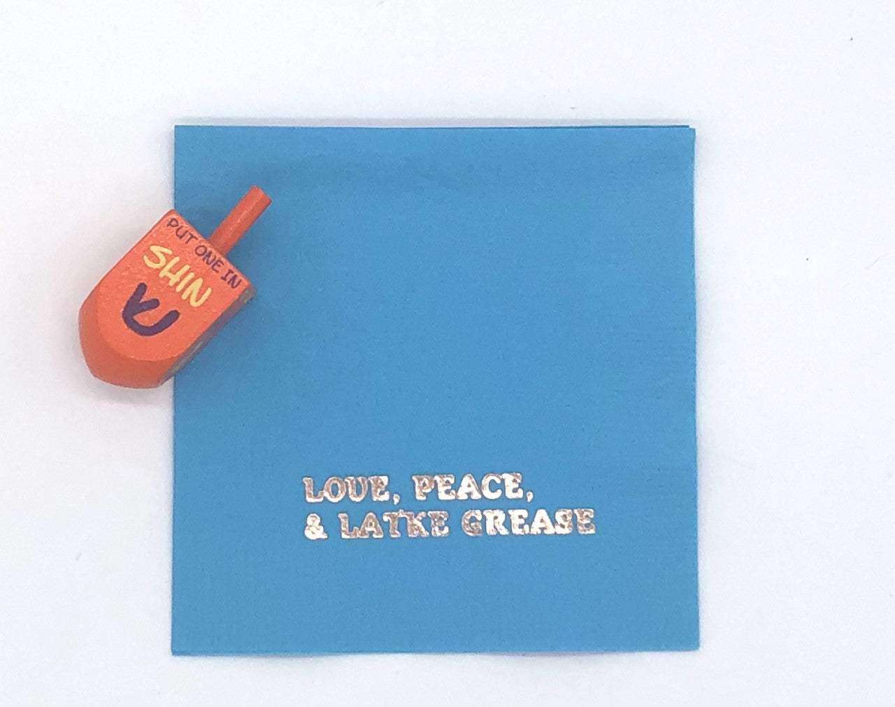 Light blue cocktail napkin with silver Love, Peace and Latke grease slogan