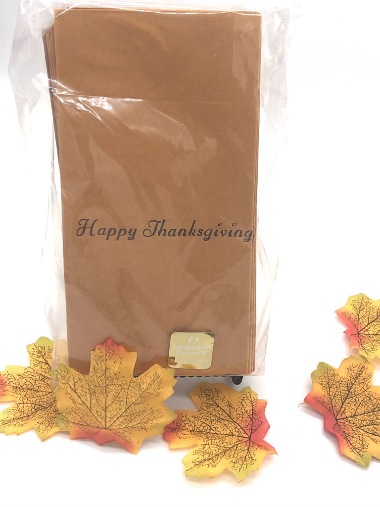 Light brown dinner napkins with a dark brown Happy Thanksgiving slogan